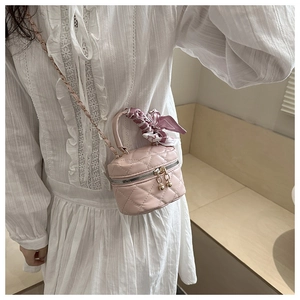 Dettaglio mini borsa rosa trapuntata con manico foulard in seta e catena dorata