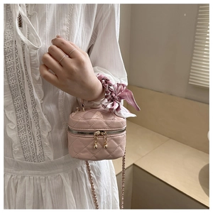 Mini borsa trapuntata rosa con foulard in seta sul manico e dettagli dorati sulla modella