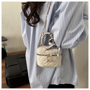 Dettaglio mini borsa trapuntata crema con zip dorate e manico avvolto in seta
