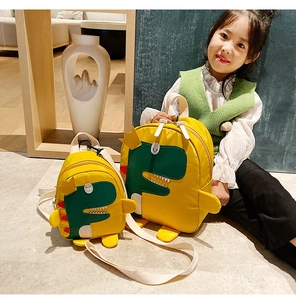Dettaglio dello zaino giallo per bambini con motivo dinosauro verde e ampie spalline