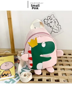 Dettaglio dello zainetto rosa per bambini in tela con patch dinosauro verde e corona