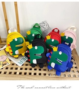 Dettaglio di zaini dinosauro colorati in nylon per bambini, giallo, verde e blu