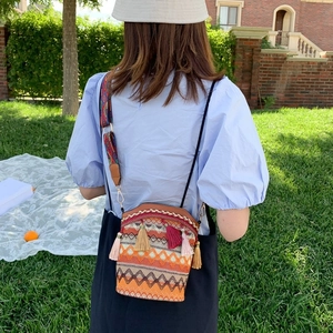 Borsa a secchiello etnica intrecciata con nappe colorate e tracolla stampata all'aperto