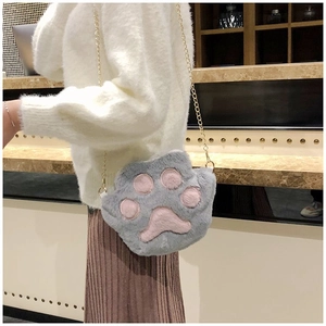 Dettaglio di una borsa a zampa in peluche grigio con inserti rosa e catena dorata