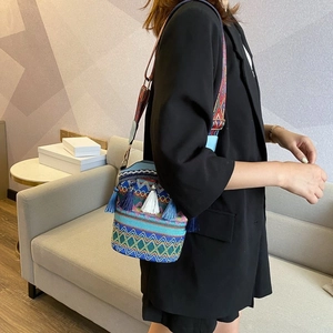 Borsa a secchiello etnica intrecciata con vivaci motivi boho e nappe con frange