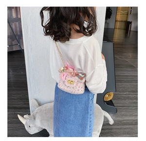 Dettaglio borsa a tracolla in tweed rosa per bambina con fiori e catena dorata