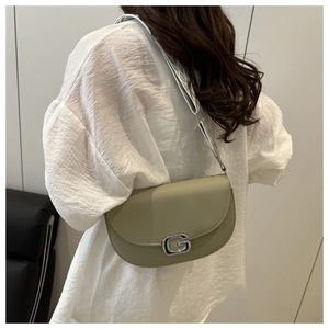 Dettaglio della borsa a sella verde con fibbia a G in diamante e tracolla a trama