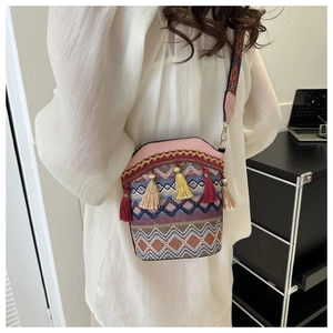 Dettaglio della borsa a secchiello bohémien con nappe colorate e tracolla jacquard