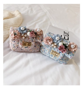 Dettaglio di mini borse a tracolla in tweed per bambina con fiori e perle