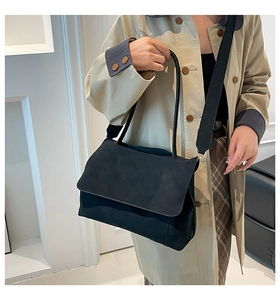 Detail of black minimalist tote bag with wide textile strap on a female model
