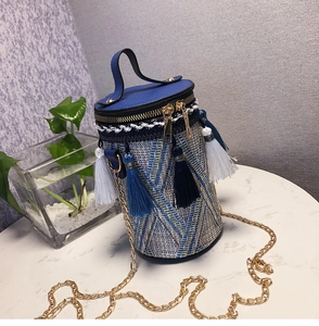 Dettaglio della borsa a cilindro intrecciata boho con motivi geometrici e nappe