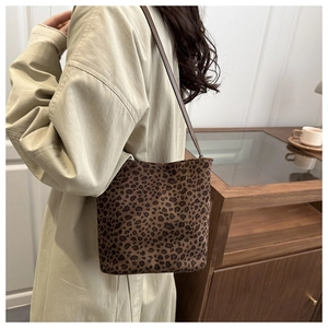 Dettaglio borsa a secchiello leopardata vintage abbinata a un trench coat beige elegante