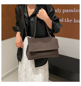Detail of dark brown tote bag showing matte texture and adjustable wide shoulder strap