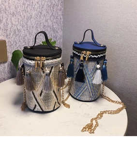 Dettaglio di borse a secchiello intrecciate con frange boho e tracolla a catena