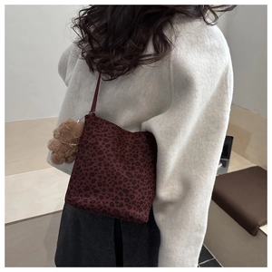 Dettaglio della borsa a secchiello leopardata con un ciondolo a forma di orsetto