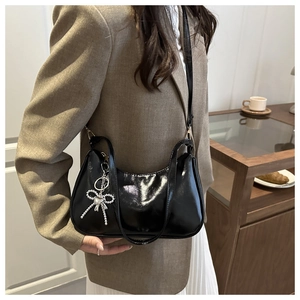 Glossy black patent leather underarm bag with a silver beaded bow charm detail