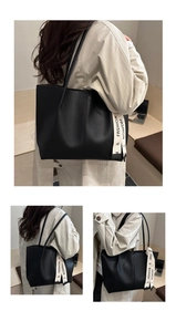 Dettaglio della grande borsa tote in ecopelle nera con nastro decorativo stampato fashion