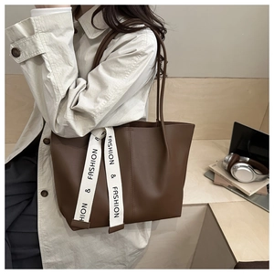Dettaglio della borsa tote in pelle marrone scuro con decorazione a nastro in tela