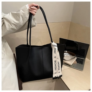 Dettaglio della borsa tote nera minimalista con nastro decorativo alla moda stampato