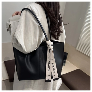 Dettaglio della borsa tote nera opaca con nastro stampato decorativo e cuciture raffinate