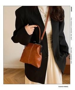 Close-up of a vintage brown leather doctor bag with metal clasp and stylish handle