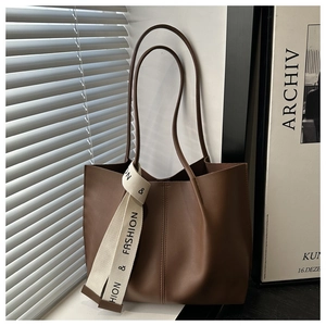 Texture dettagliata della borsa tote in pelle marrone scuro con nastro decorativo