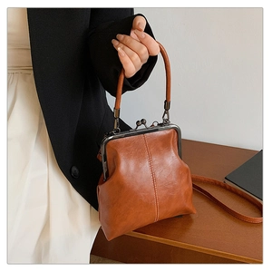 Detail of vintage brown doctor bag with metal clasp and leather texture on a wooden desk