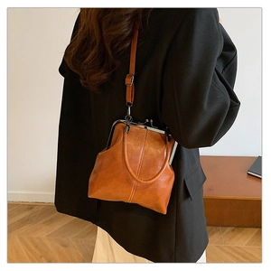Detail view of a vintage brown doctor bag featuring a classic metal frame and top handle