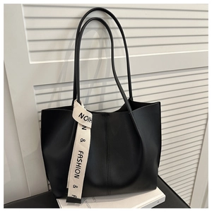 Dettaglio della borsa tote nera in pelle PU con elegante nastro bianco decorativo sul manico
