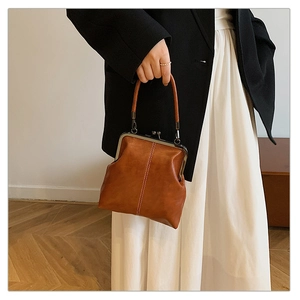 Detail of vintage brown leather doctor bag with metal clasp and vertical stitching