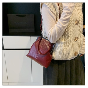 Détail du sac à bandoulière vintage rouge foncé avec fermoir rétro et poignée