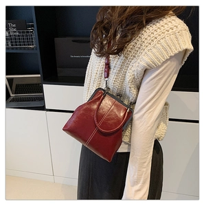 Close-up of vintage burgundy doctor bag featuring white contrast stitching and metal clasp