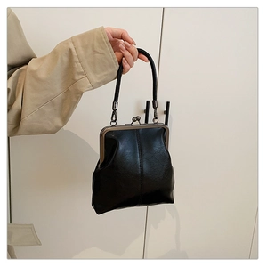 Macro detail of retro black leather doctor bag with vintage metal kiss-lock and handle