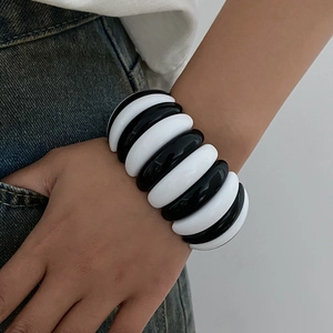 Macro detail of chunky black and white resin link bracelet on model's wrist
