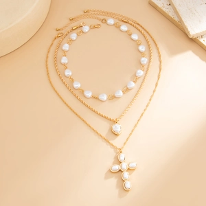 Vue détaillée du collier triple rang doré avec perles baroques et pendentif croix