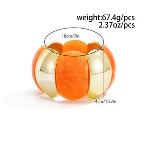 Dettaglio del bracciale rigido oro e resina arancione con misure e peso specificati