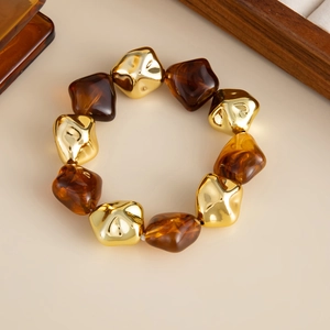 Dettaglio del bracciale vintage con perle geometriche in resina ambra e metallo oro