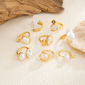 Detailed set of eight baroque pearl rings in gold finish with vintage textured metal detail