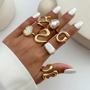 Dettaglio di anelli a fascia impilabili con perle barocche e design artistico irregolare oro