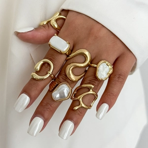 Set di anelli barocchi dorati con perle irregolari sulla mano della modella