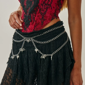 Detail of gothic silver waist chain featuring layered moth and bat pendant charms