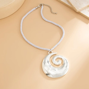 Macro detail of silver spiral shell pendant on a white chunky twisted rope chain necklace