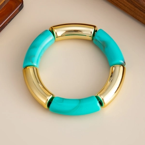 Detalle de una pulsera boho con textura turquesa y segmentos de metal dorado pulido
