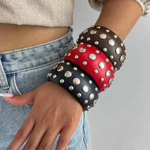 Lot de trois bracelets punk en cuir large avec clous argentés portés sur le bras
