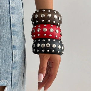 Trois bracelets larges de style punk avec clous argentés portés pour un look tendance