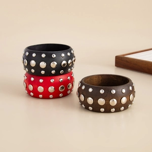 Détail de larges bracelets en bois rétro avec rivets métalliques en trois coloris divers