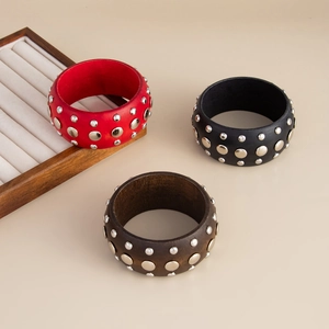 Détail de joncs en bois style punk avec clous argentés en rouge, noir et marron