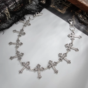 Detail of gothic cross pendants and lobster clasps on a punk style silver metal waist chain