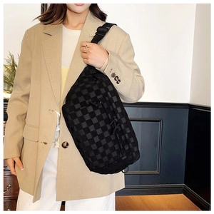 Close-up of checkered crossbody chest bag with adjustable strap worn on model