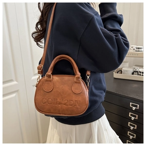 Brown vintage leather handbag with embossed letters and adjustable crossbody strap detail